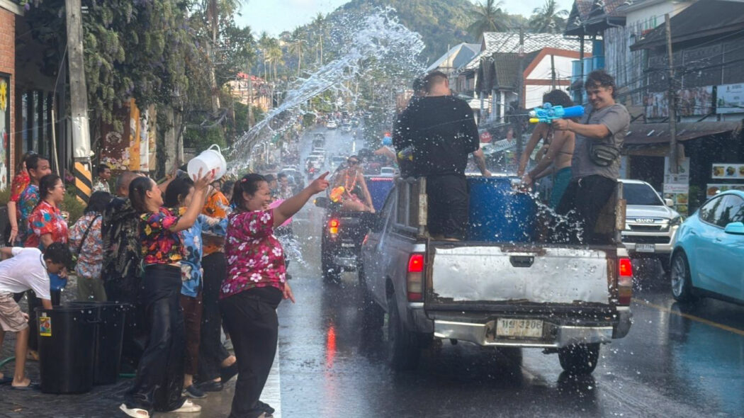 Songkran water festival 2026 Koh Samui – locals and tourists having a water fight on the street during Thai New Year celebrations