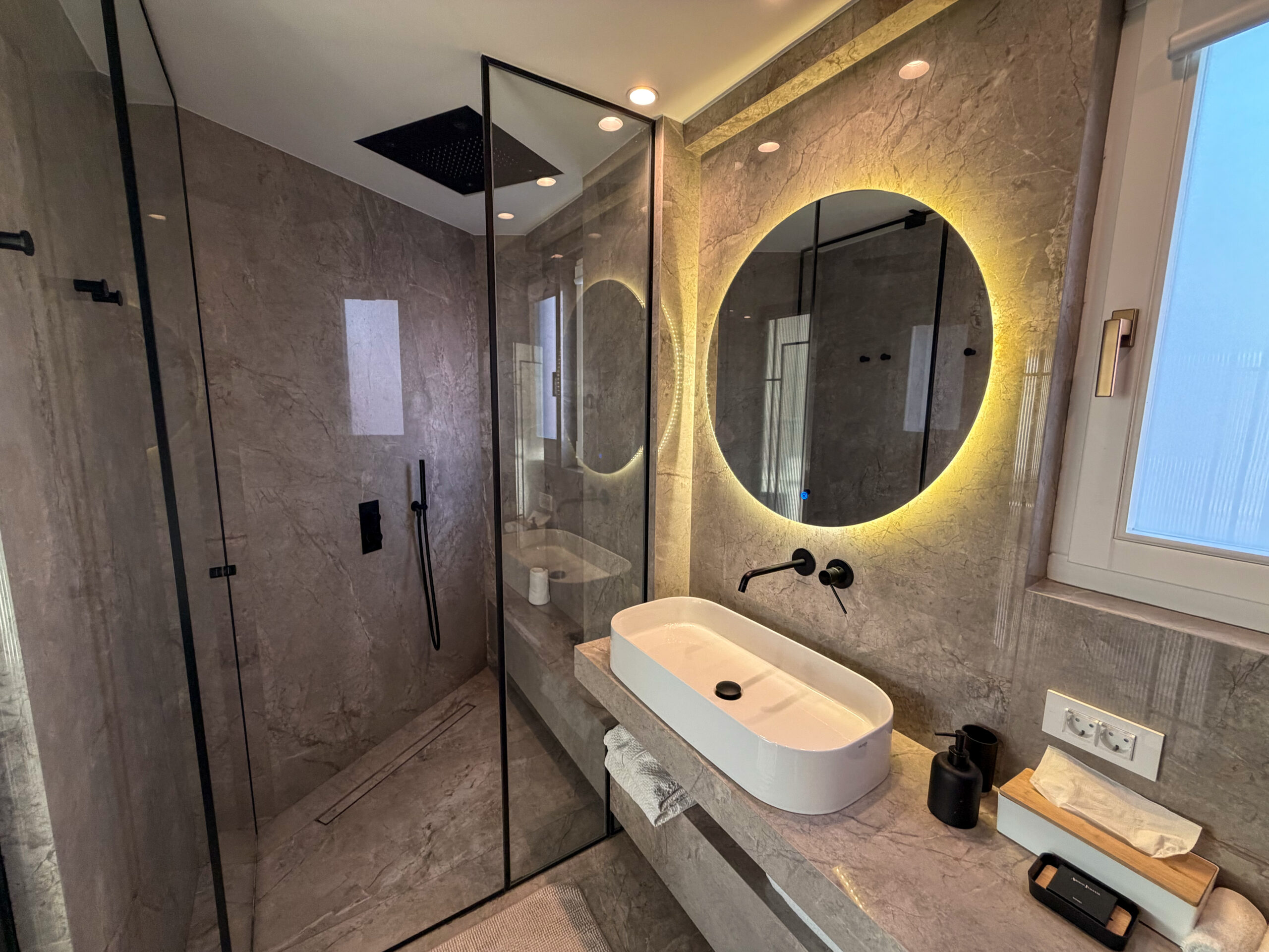 Luxury marble bathroom with overhead shower at Riviera Suites Chania