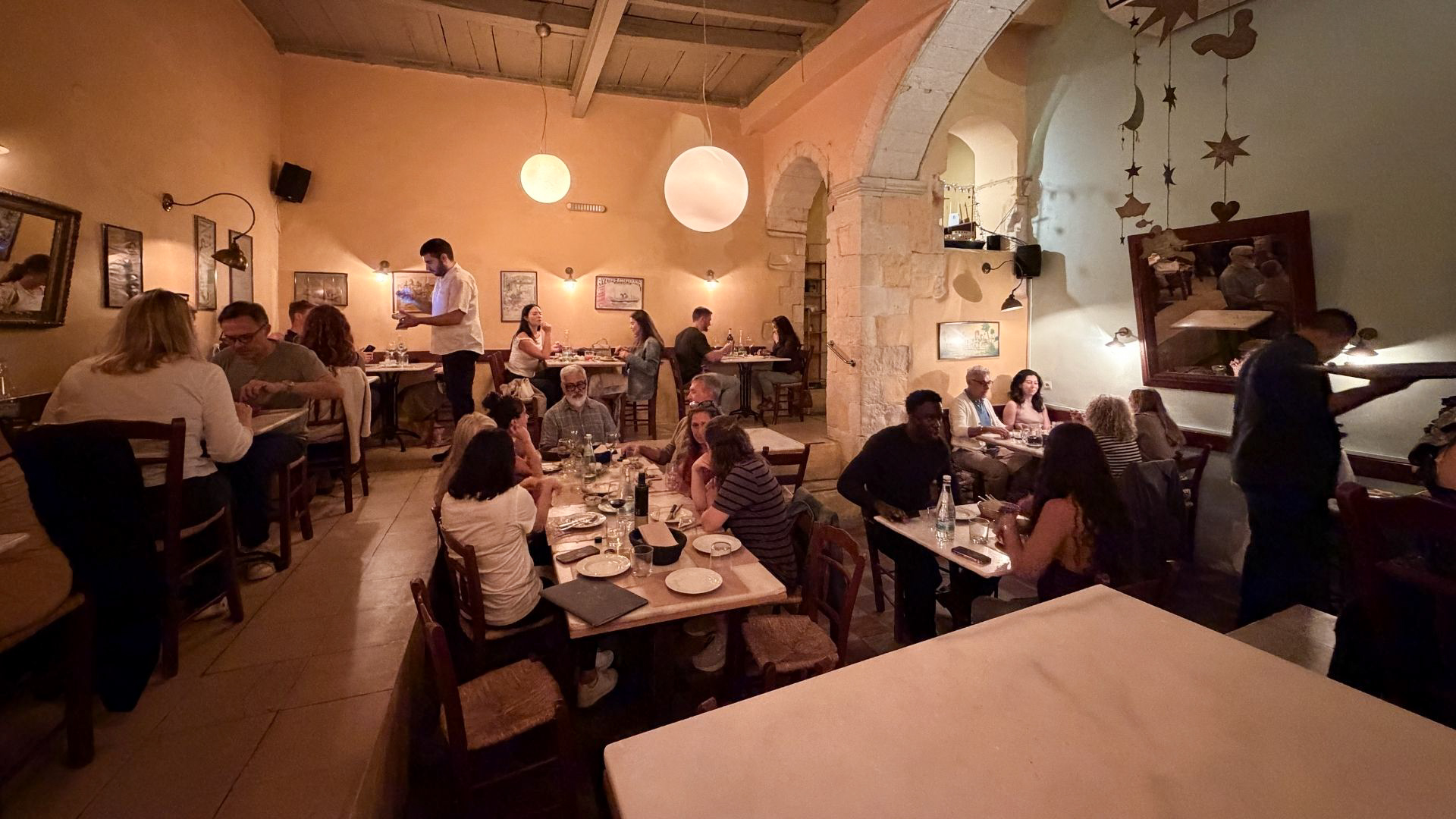 Atmospheric restaurant interior with red lighting and candlelit tables in Chania, Crete