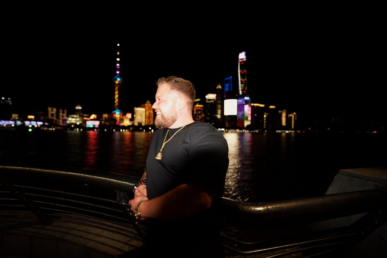 Samuli Makkonen on the Bund at night with the Shanghai skyline behind him